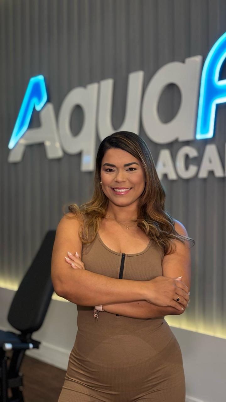 Thamyres Balbino sorrindo, de braços cruzados, em uma academia